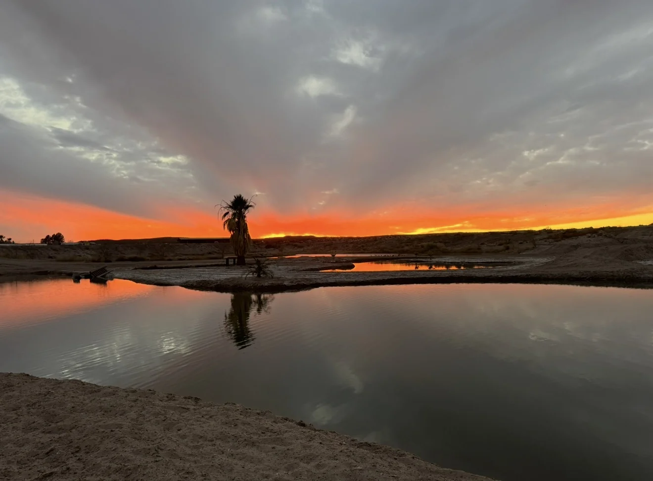 Orange sunset reflected in the private ranch lake